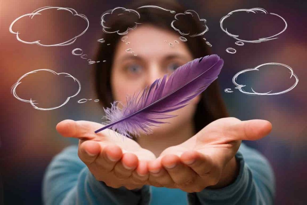 Person contemplating the meaning of a purple feather with symbolic thought bubbles