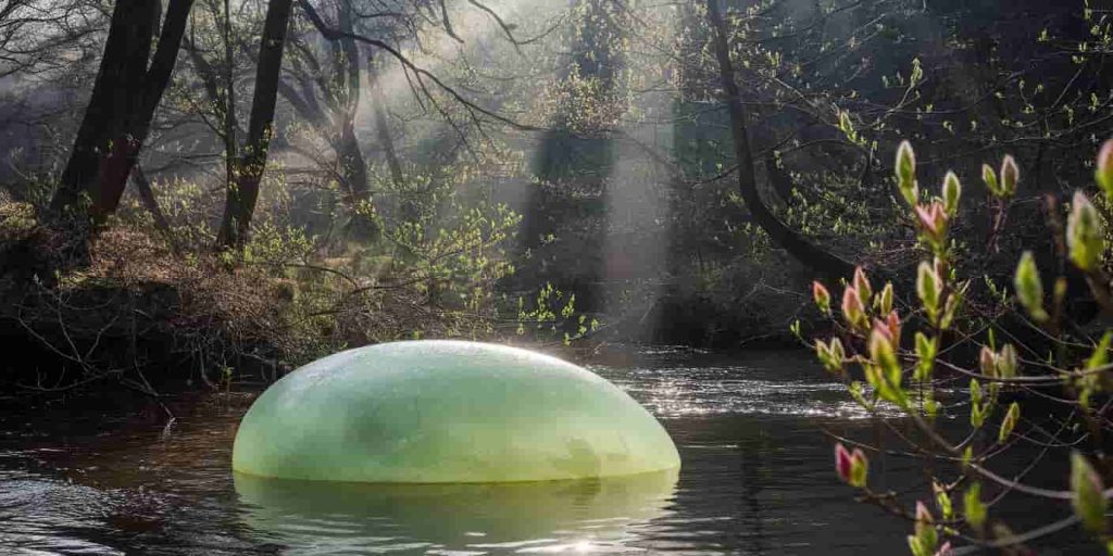 A green jade stone in a forest stream, surrounded by symbols of growth and renewal.